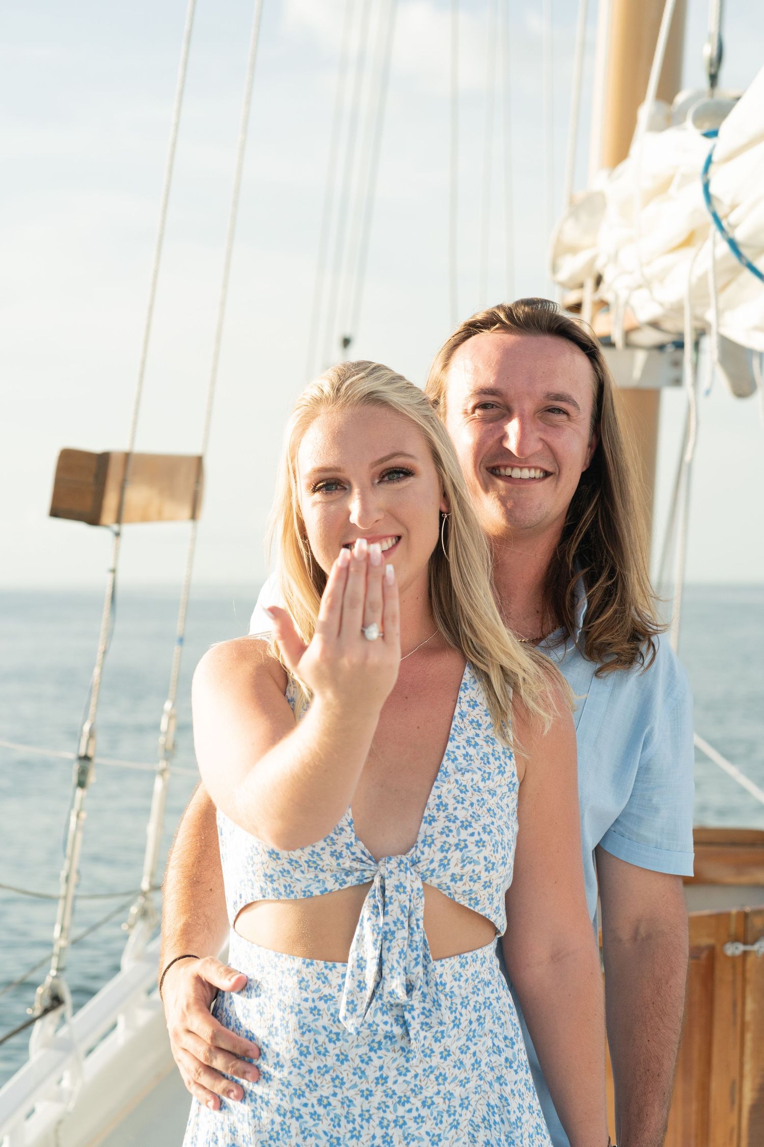 Couple sharing a joyful moment together on a sailboat during sunset.