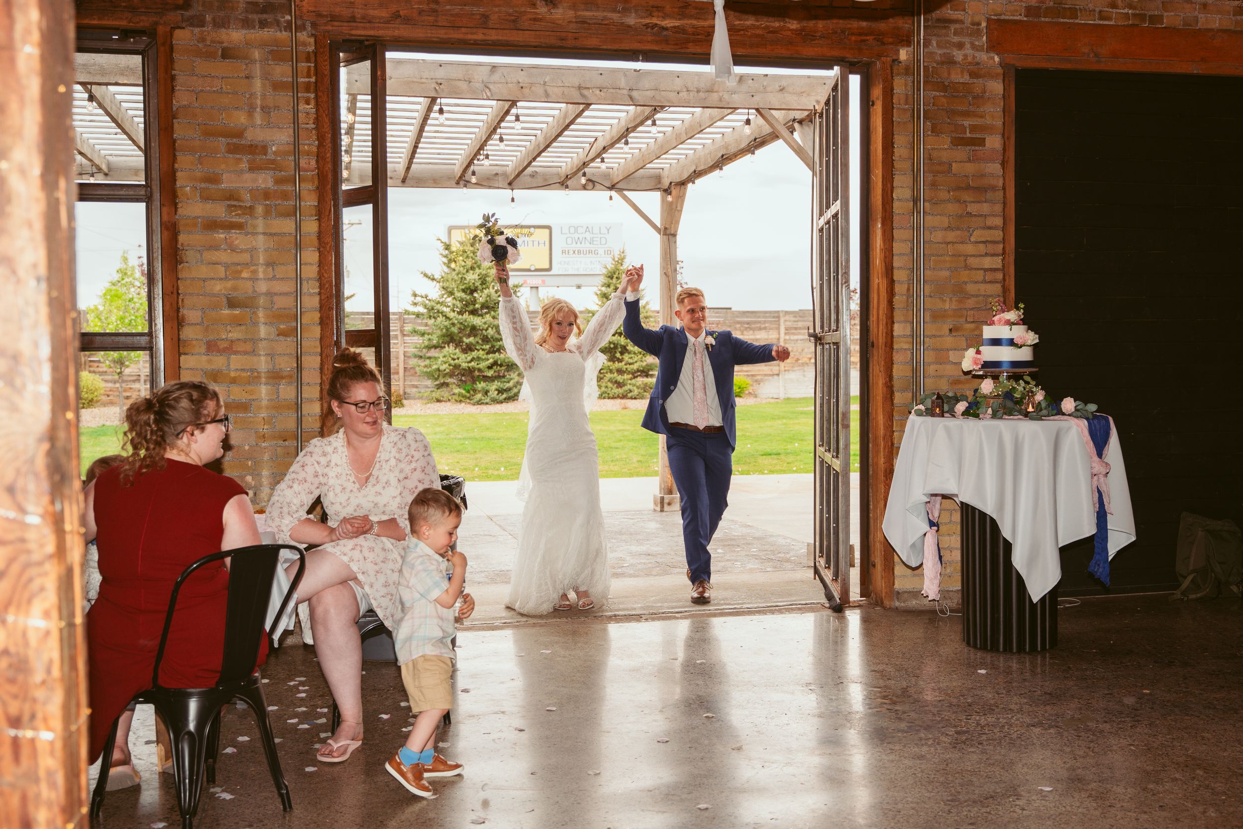 Indoor wedding venue with exposed brick walls and natural lighting from outdoor area.