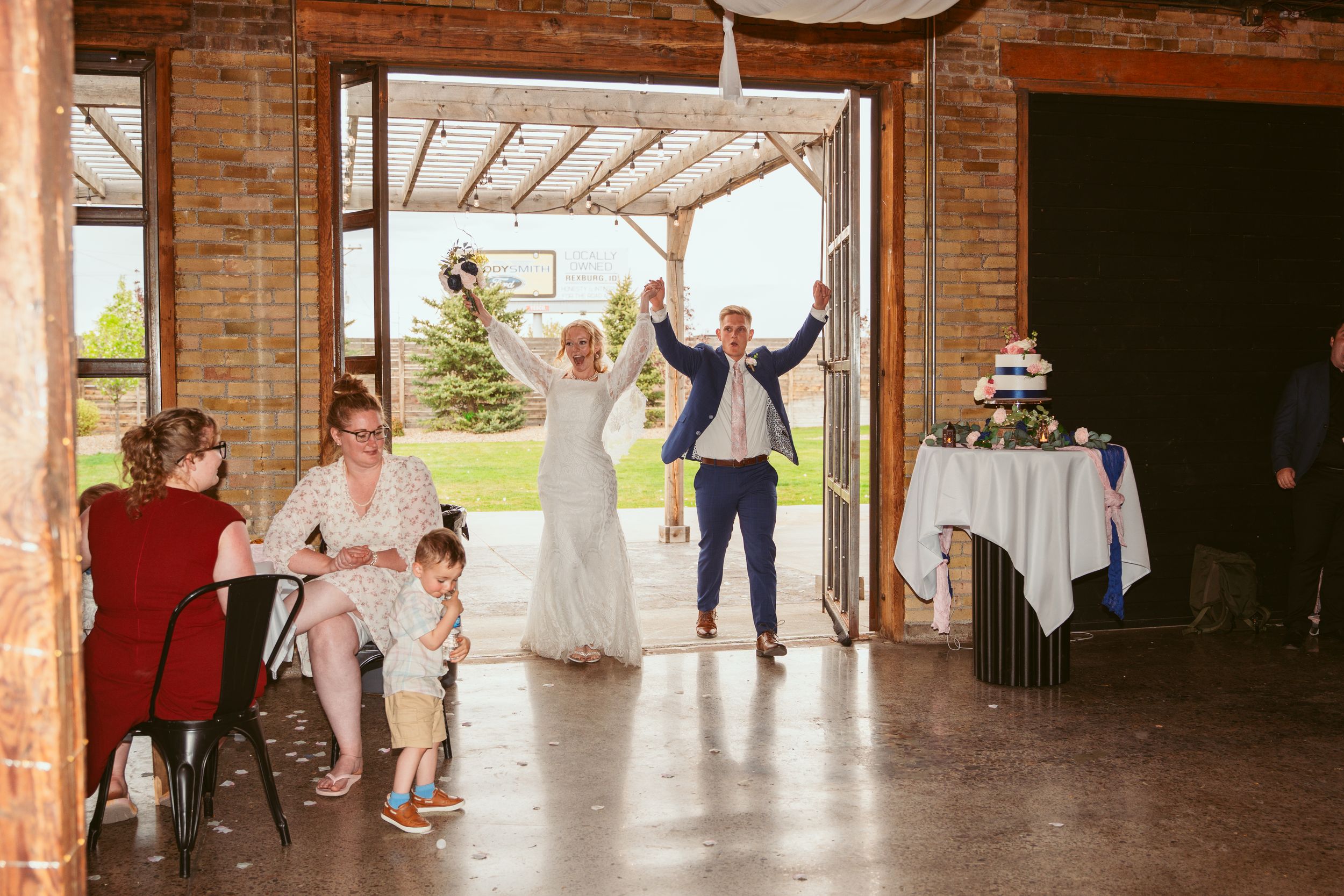 Wedding celebration inside a brick venue with guests cheering during the reception festivities.