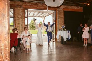 Rustic wedding reception space with brick pillars and wooden ceiling beams.