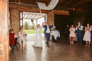 Wedding celebration with dancing couples in a renovated industrial barn space with brick walls.