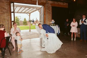Wedding celebration in progress at indoor-outdoor venue with brick architecture.