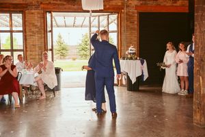 Wedding reception in a rustic brick venue with large windows and wooden floors.