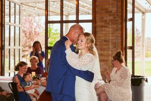 Couple shares their first dance in an elegant brick-walled reception venue.