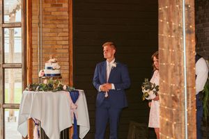 Newlyweds dance together in a rustic venue with exposed brick walls and string lights.