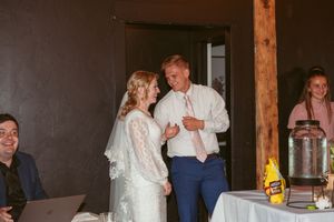 Festivities continue at a barn reception as guests dance under ambient lighting.