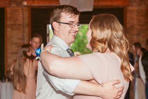 A couple dancing together at a wedding reception in casual attire.