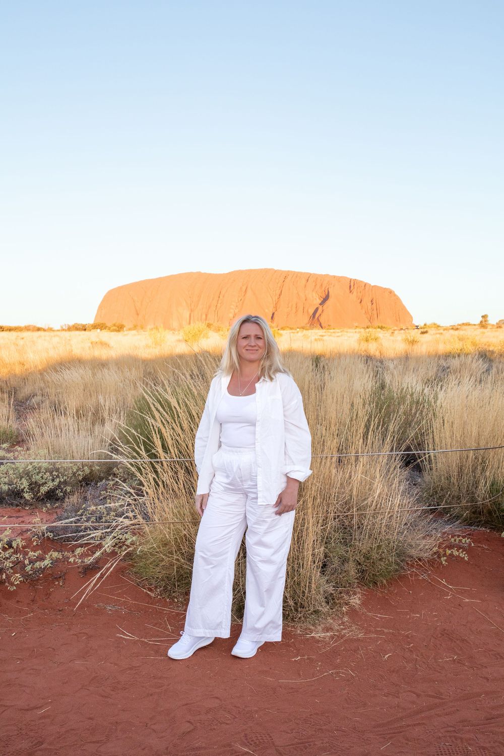 Scenic view of red rock formations in the Australian outback with native desert grasses in the foreground.