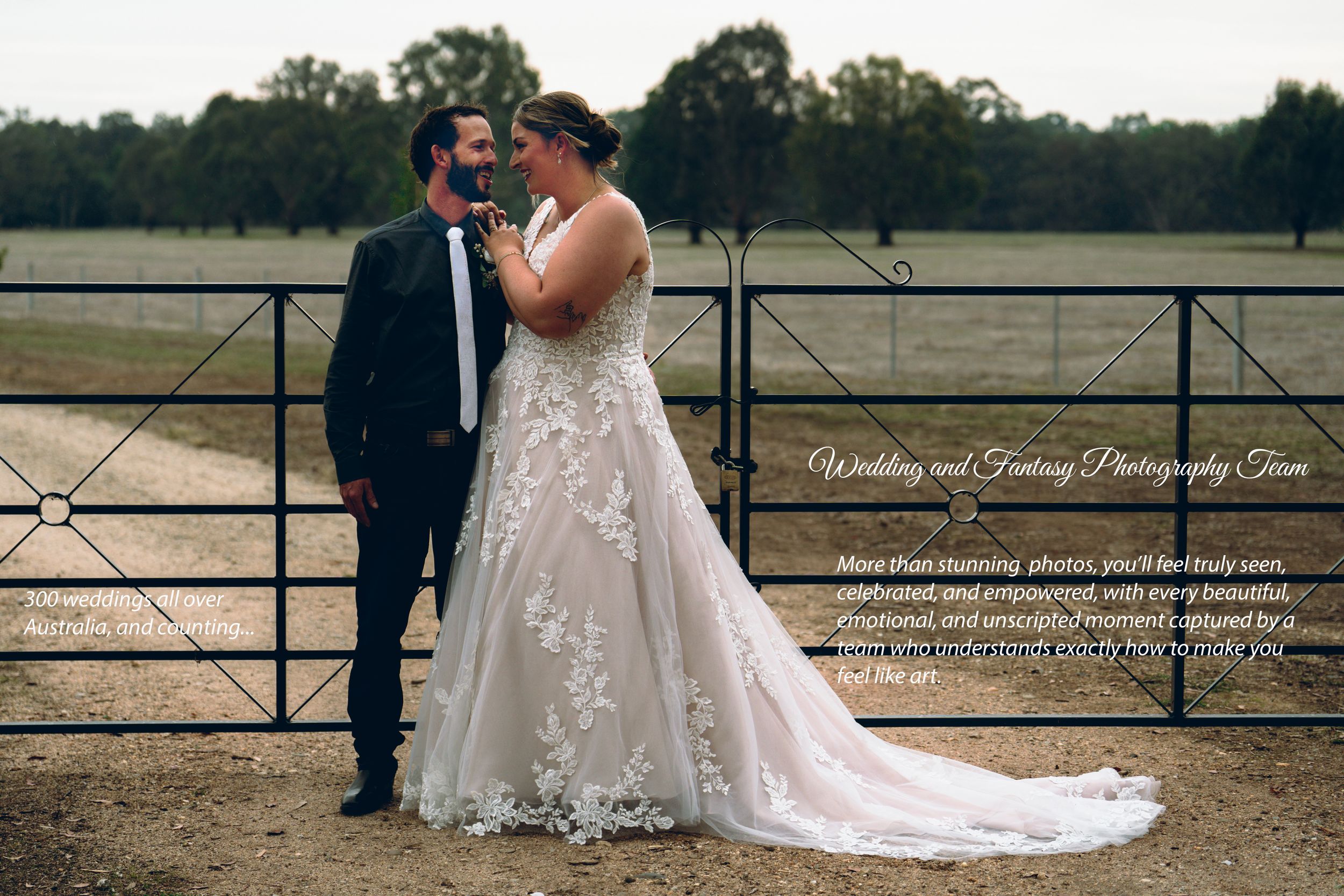 A couple in formal wedding attire stands together by a rustic fence at sunset in a countryside setting.
