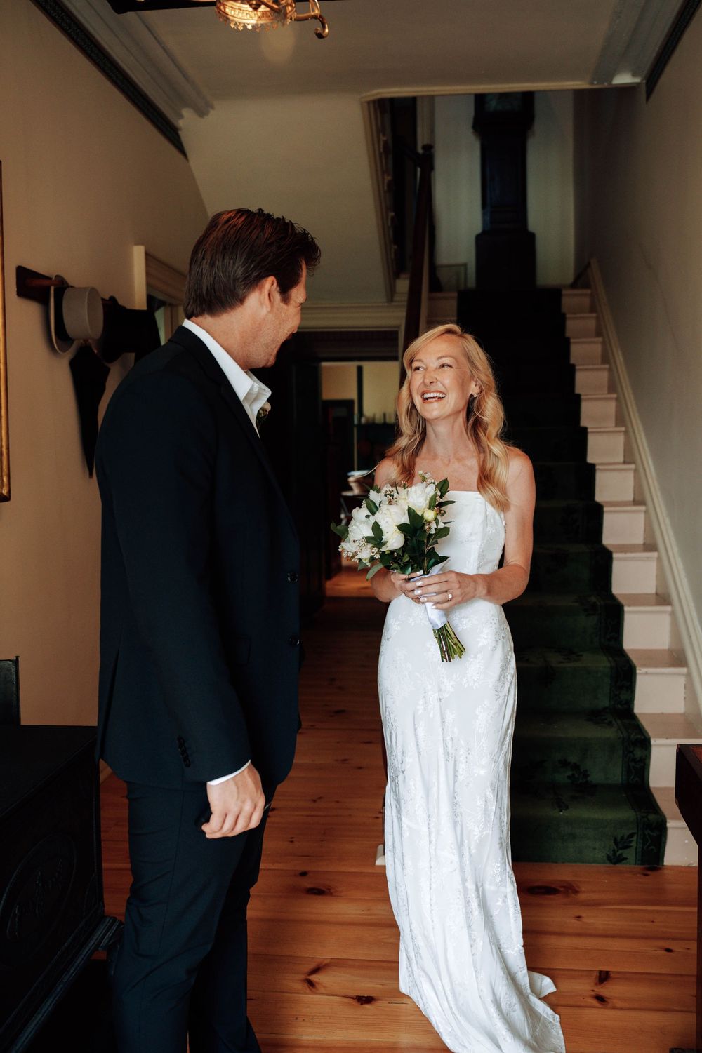 A romantic portrait series of a couple embracing on a wooden staircase during their wedding.