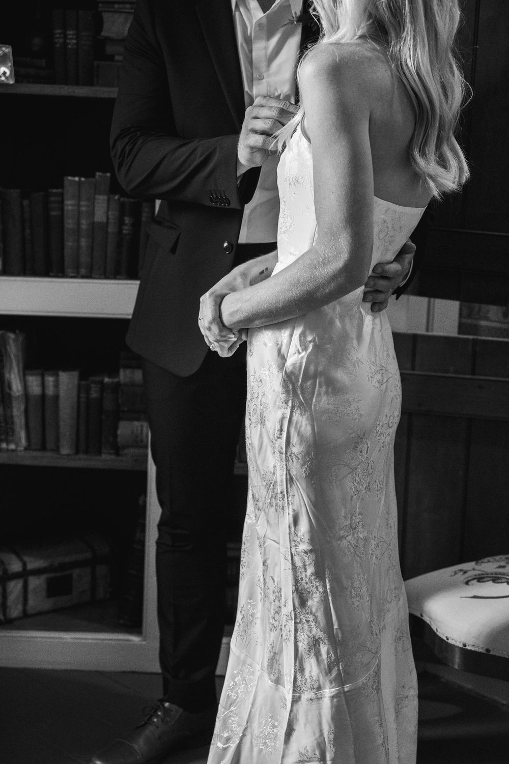 Black and white detail shot of bride and groom's formal wedding attire.