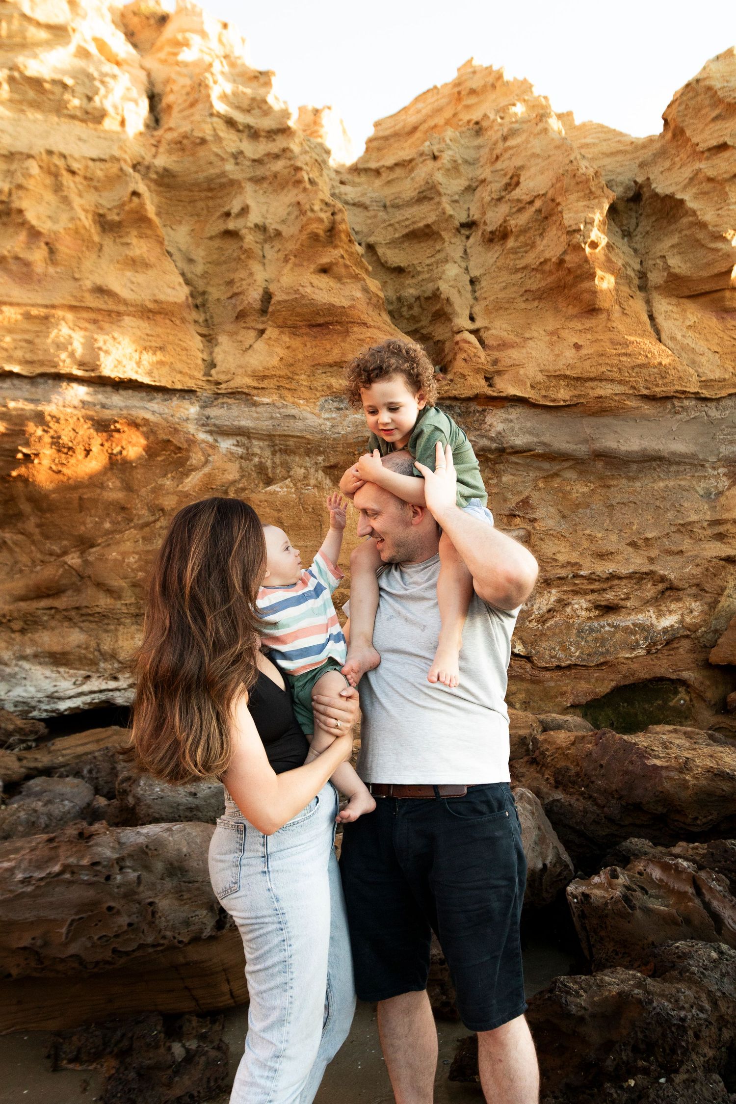 A family shares a joyful moment together against red rock formations at sunset.
