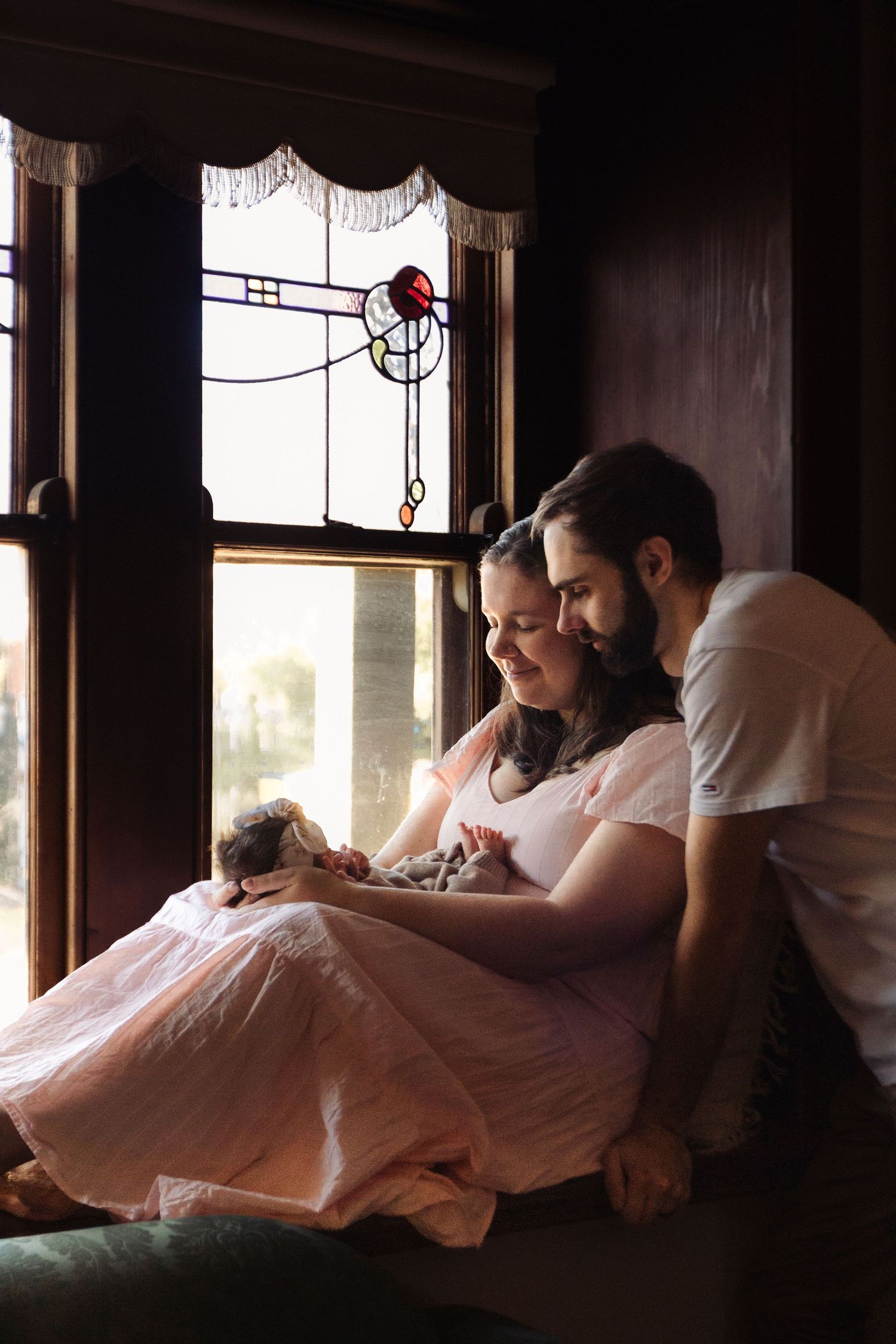 Intimate indoor scene in moody lighting with soft bed linens.
