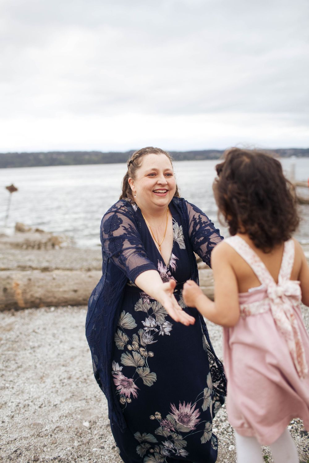 A mother and her daughter share a joyful moment together laughing at Mukilteo beach in Washington