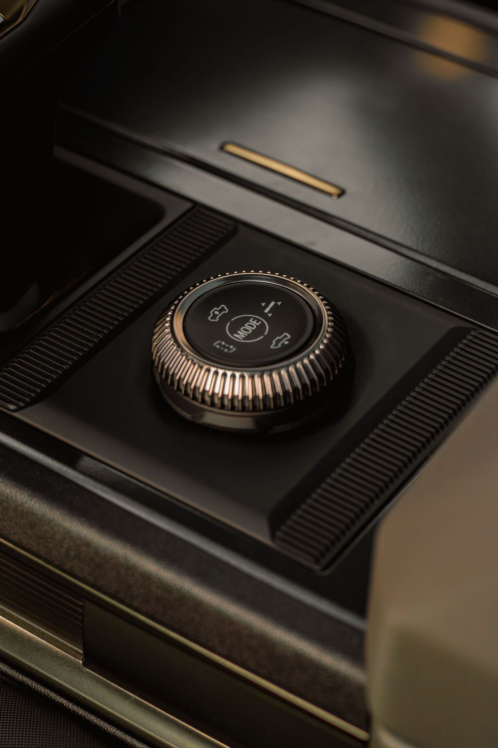 Close-up macro shot of black volume control knobs with copper accents on audio equipment in dark lighting.