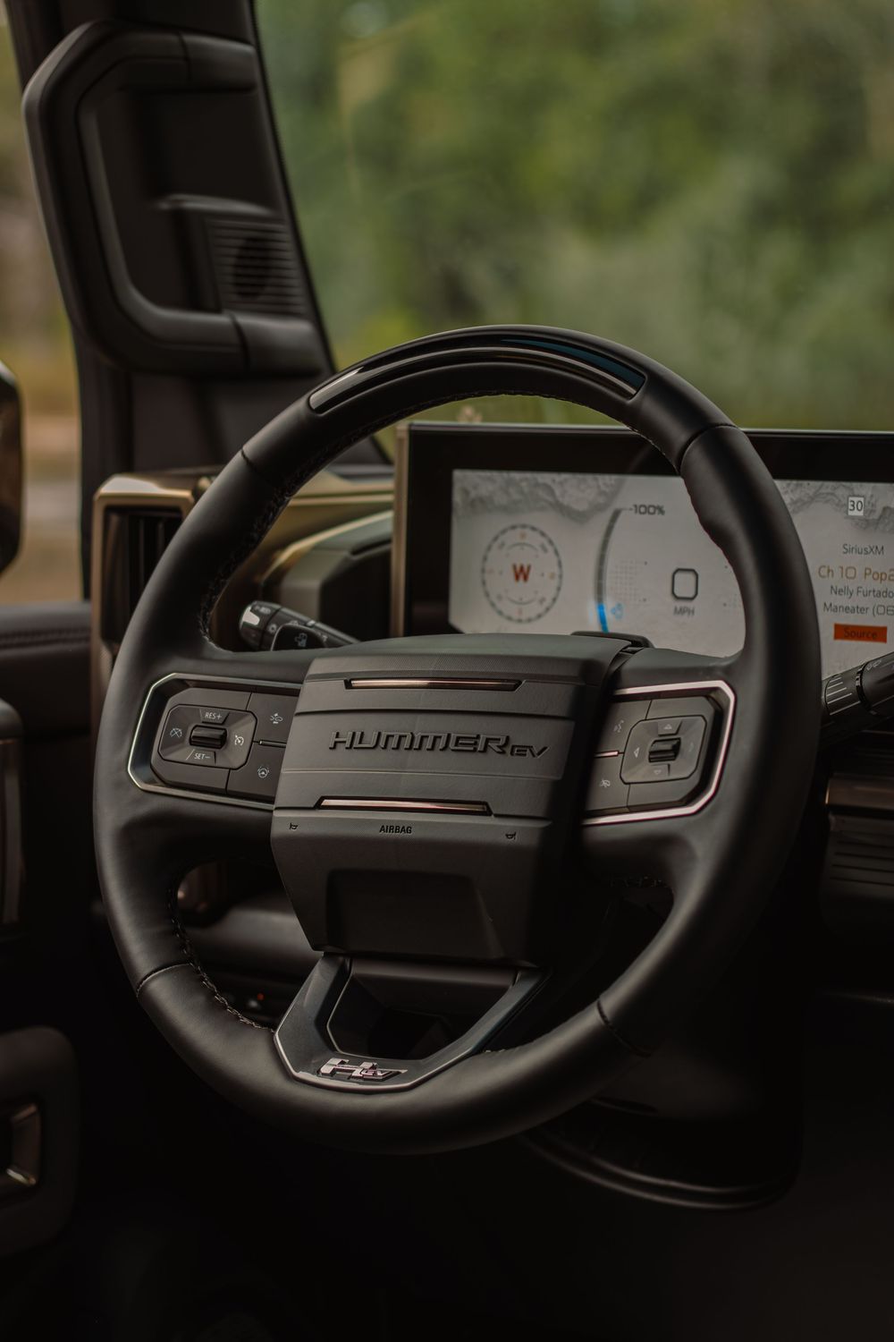 Close-up view of vintage car steering wheel showing analog dashboard gauges and controls.