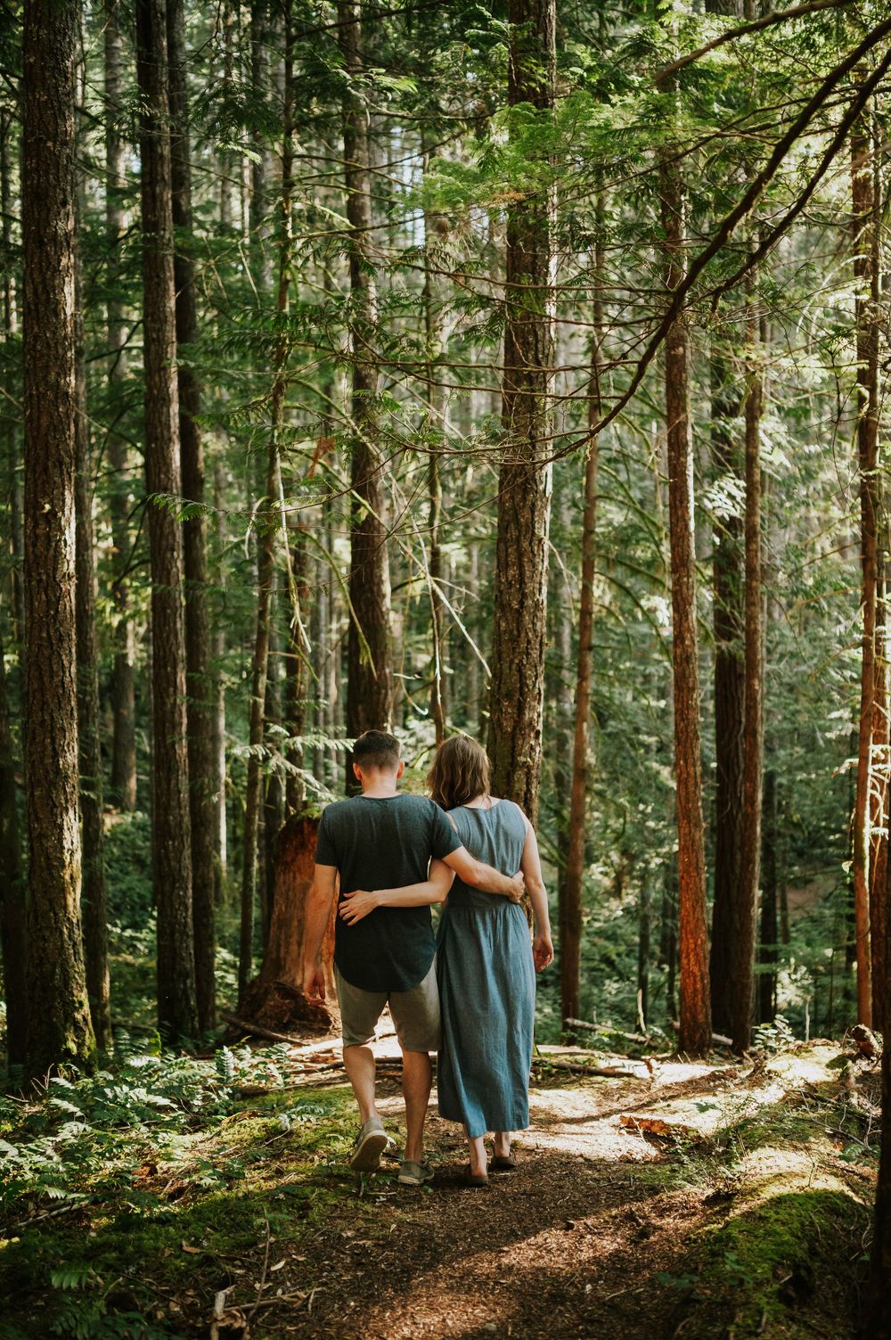 Adventurous couple photographer photoshoot of couple in Cumberland Forest Vancouver Island engagement session walking in forest hugging