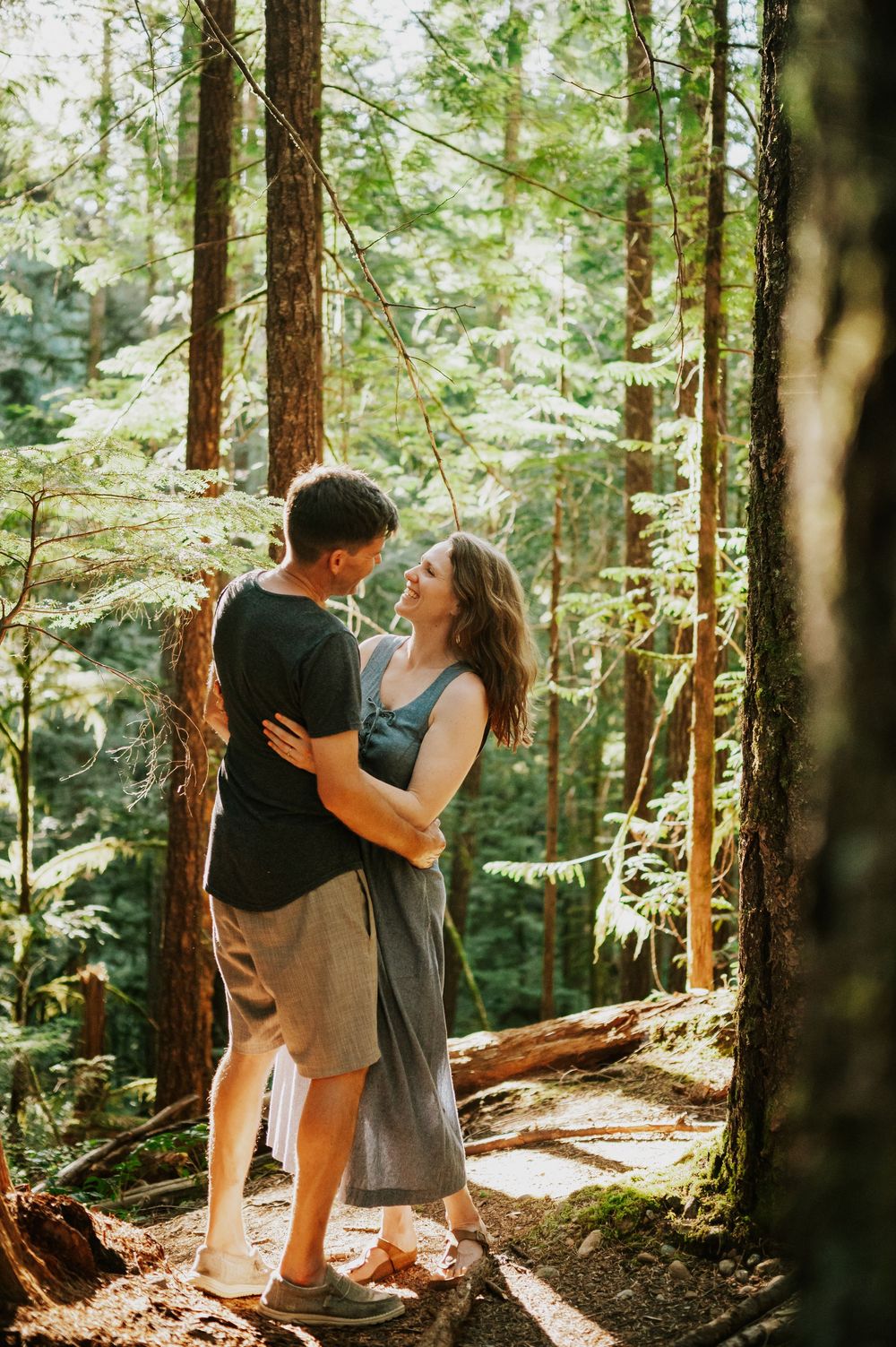 Adventurous couple engagement session photographer photoshoot of couple in Cumberland Forest Vancouver Island hugging and smiling