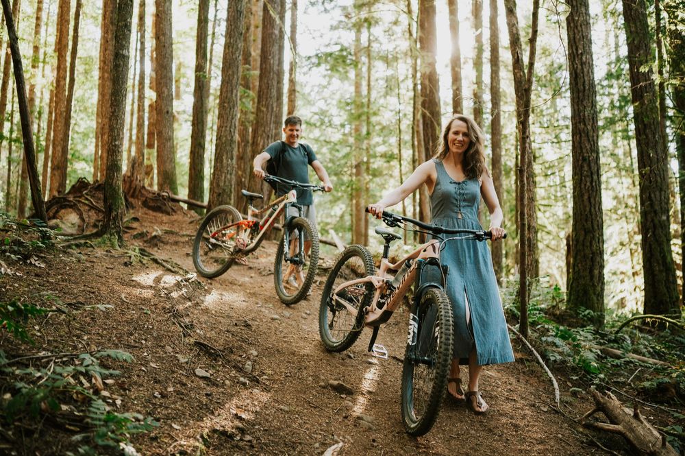 Adventurous couple engagement session photographer photoshoot of couple in Cumberland Forest Vancouver Island walking bikes