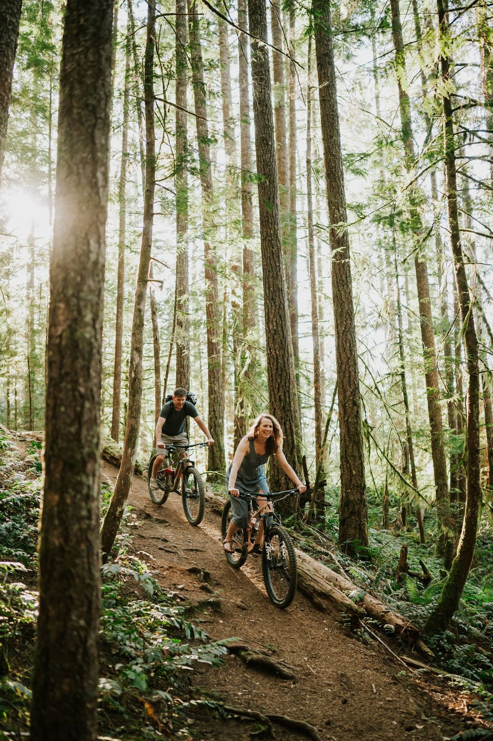 Adventurous couple engagement session photographer photoshoot of couple in Cumberland Forest Vancouver Island riding mountain bikes