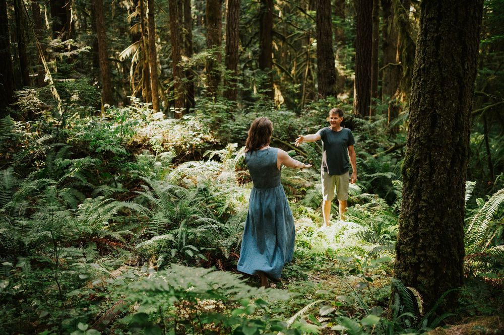 Adventurous couple photographer photoshoot of couple in Cumberland Forest Vancouver Island engagement session snuggling in ferns