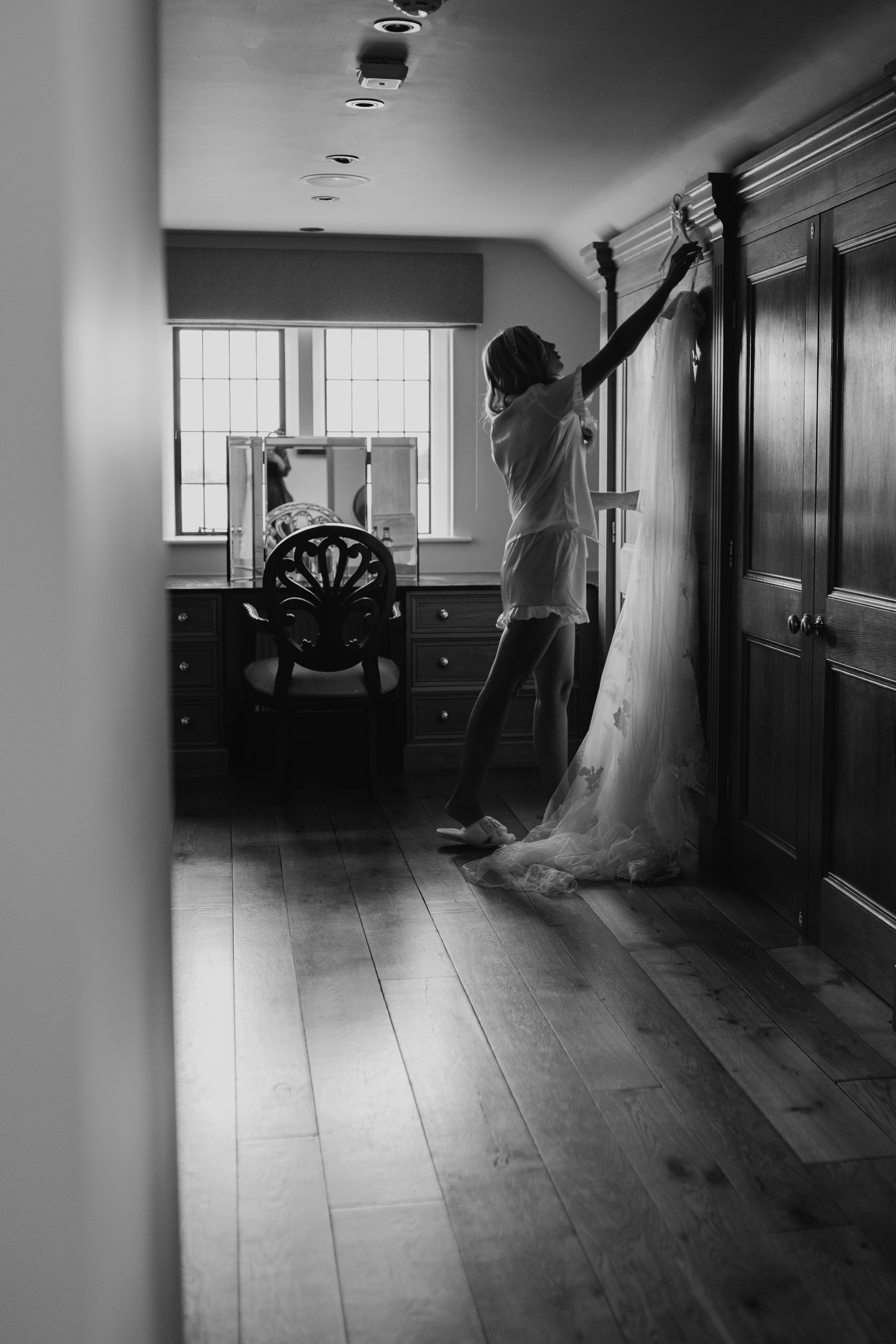 A black and white photo series shows a person in a flowing white dress dancing through an empty hallway at Merrydale Manor