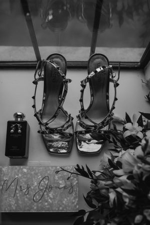 Black and white photo of vintage style horse riding saddles displayed in a row.