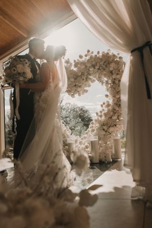 A series of dreamy sepia-toned wedding dress photographs showing elegant bridal gowns in a softly lit interior space.