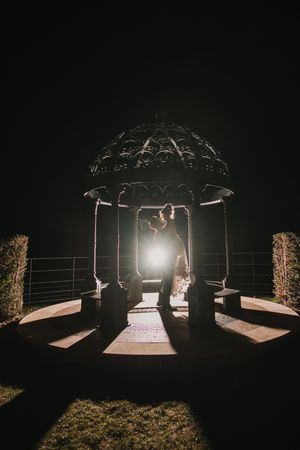 A sequence of nighttime wedding ceremony shots showing an illuminated gazebo structure against a dark background at Merrydale Manor