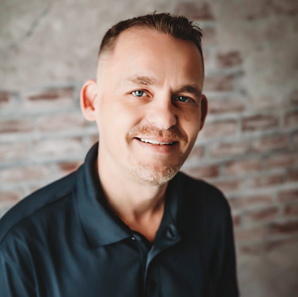 Professional headshots against brick wall background with warm lighting.