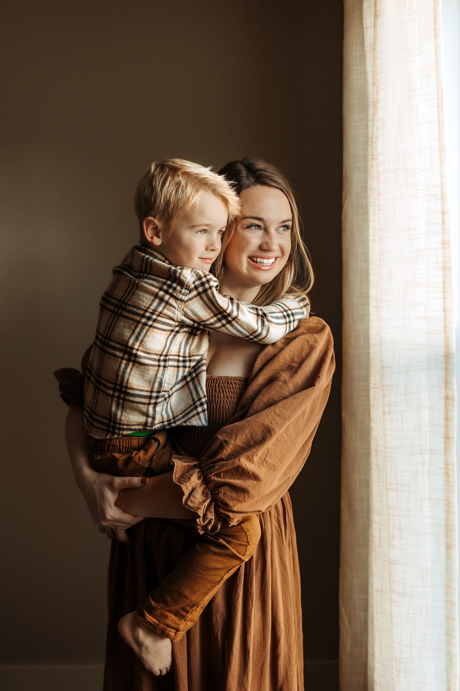 Mom and young son looking out the window in Maryville, TN studio photoshoot