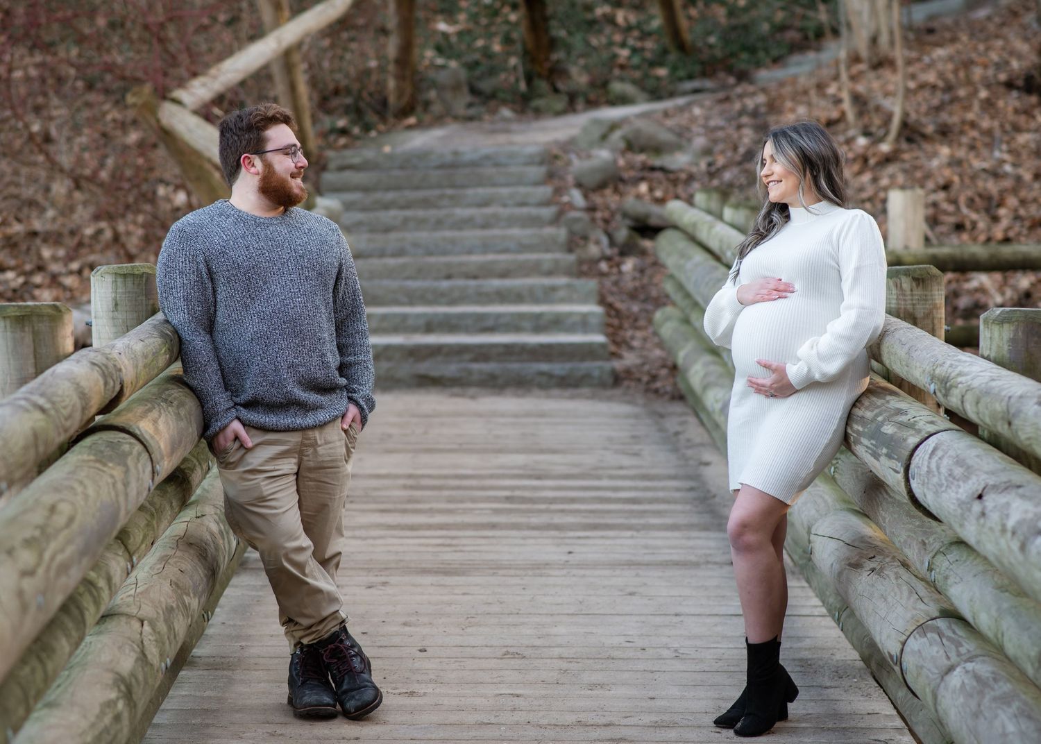 Family members hold hands while walking along a wooded trail during a lifestyle photography session outdoors.