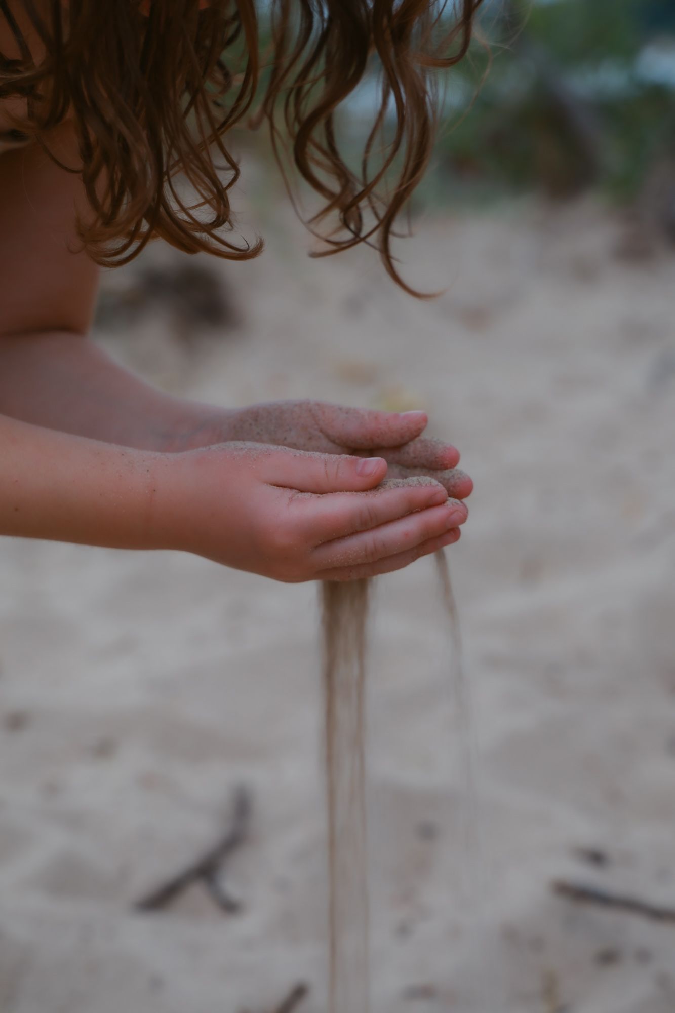 A sequence of images showing sand falling through an open palm against a blurred natural background.