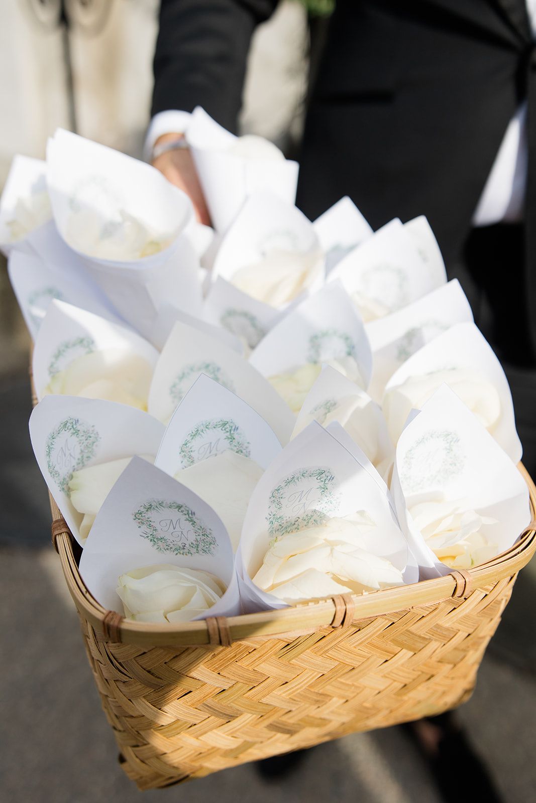 White paper cones filled with confetti arranged in woven baskets for a wedding celebration.