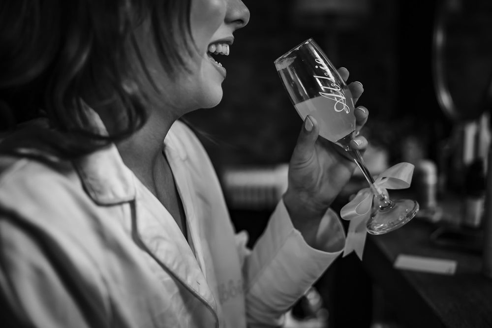 A series of black and white photos showing someone holding and drinking from a glass in a dark setting.