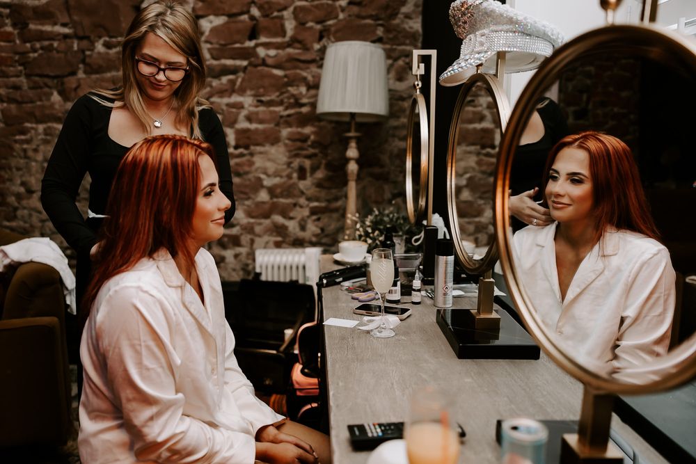 A series of candid moments captured in a rustic brick-walled salon setting showing hair styling preparations.