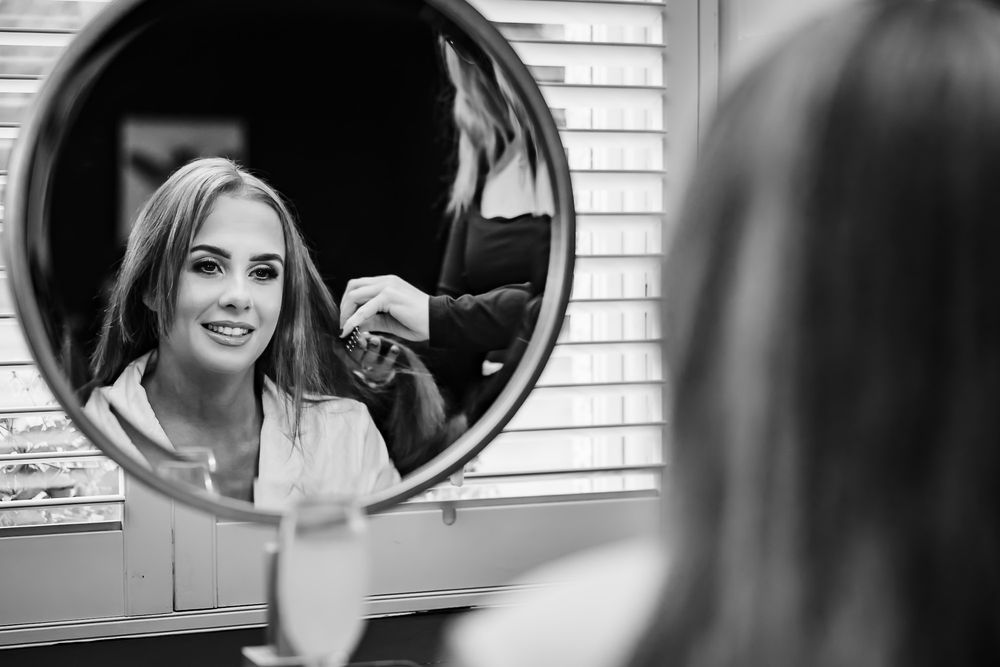 Black and white reflections in salon mirrors show styling preparations in progress.