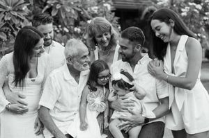 A series of candid black and white photos showing joyful moments of laughter and embraces outdoors.
