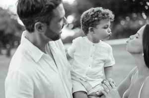 A black and white collage of candid family moments shows people in white shirts outdoors enjoying time together.