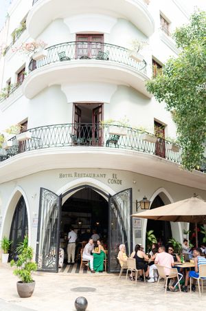 Panoramic view of a white Mediterranean-style restaurant building with arched entrances and outdoor seating areas.