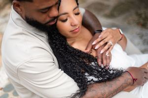 Romantic couple in white outfits sharing tender moments during an intimate photoshoot.