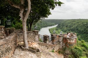 Panoramic view of a scenic overlook with stone walls and benches along a forested mountain ridge in summer.