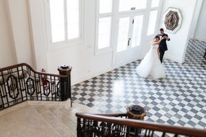 A classic black and white checkered floor pattern stretches across a bright, sunlit interior space with white walls.
