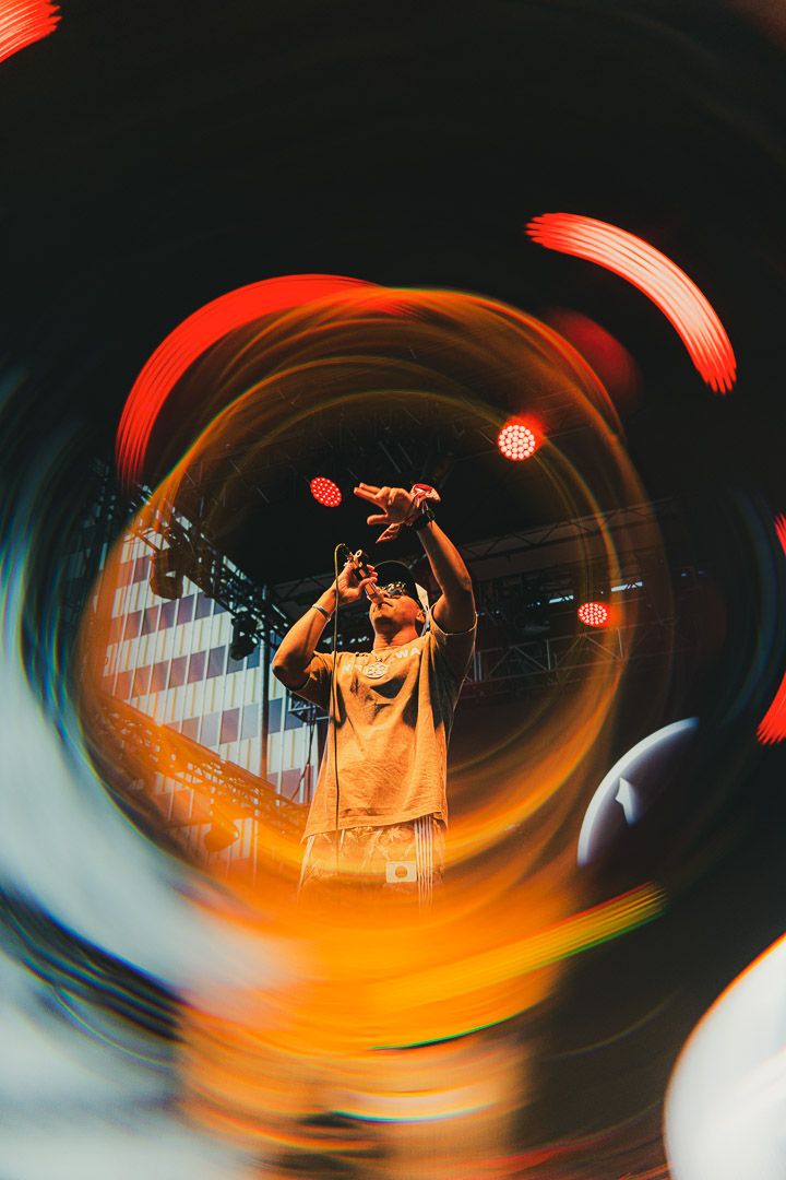 Concert photography with orange light trails and motion blur effects creating dynamic performance shots.