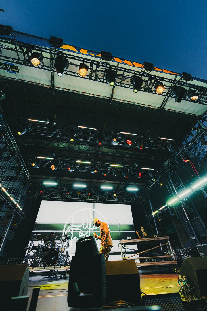 Wide angle view of a concert stage setup with professional lighting equipment and sound gear.