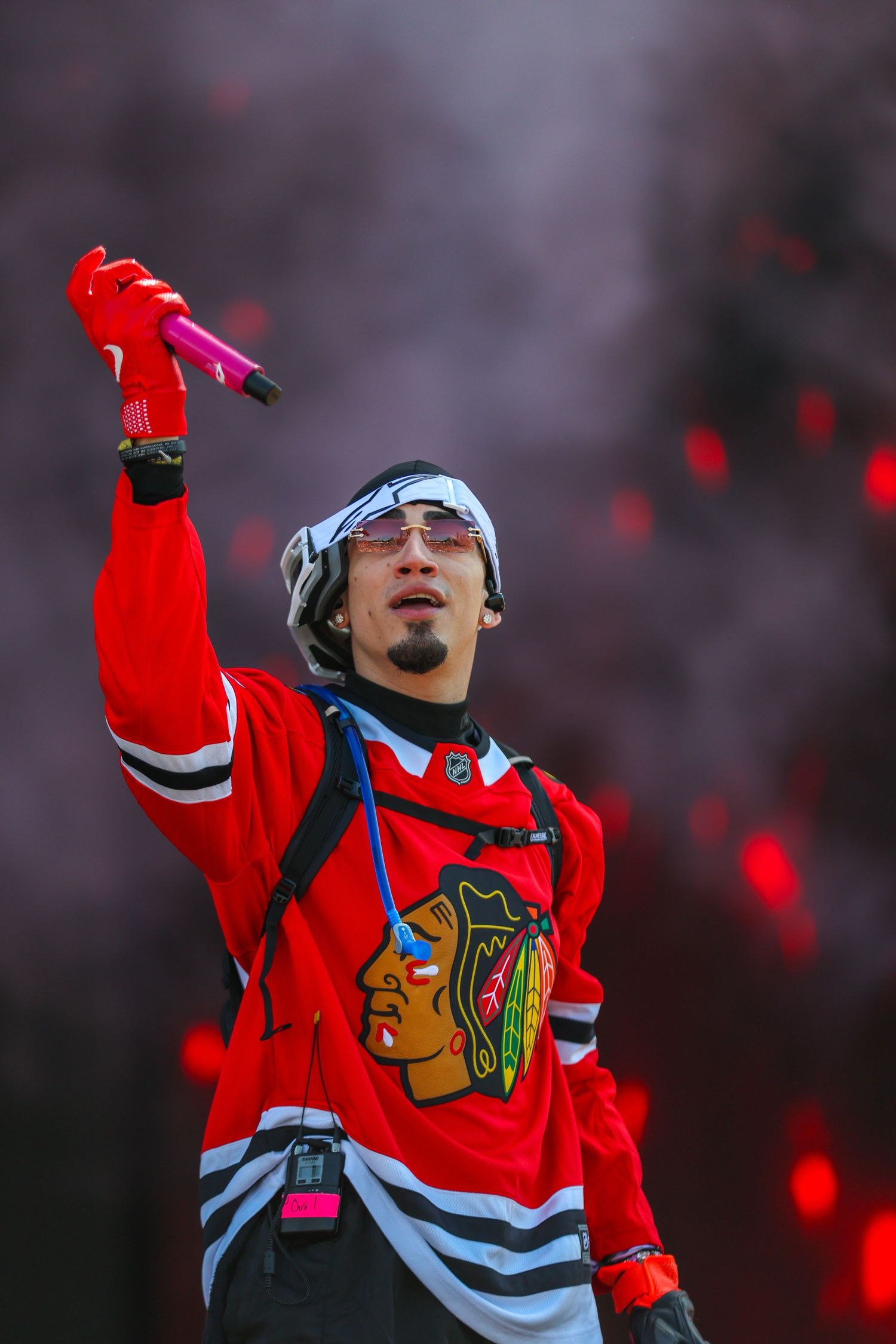 Chicago Blackhawks player in red jersey celebrates with arms raised during a game at the United Center.