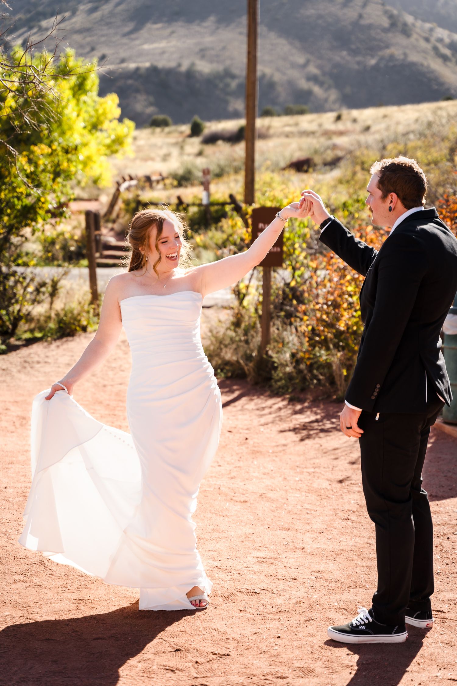 A couple poses at the iconic Red Rocks Amphitheatre in Colorado with its dramatic sandstone seating and scenic backdrop.