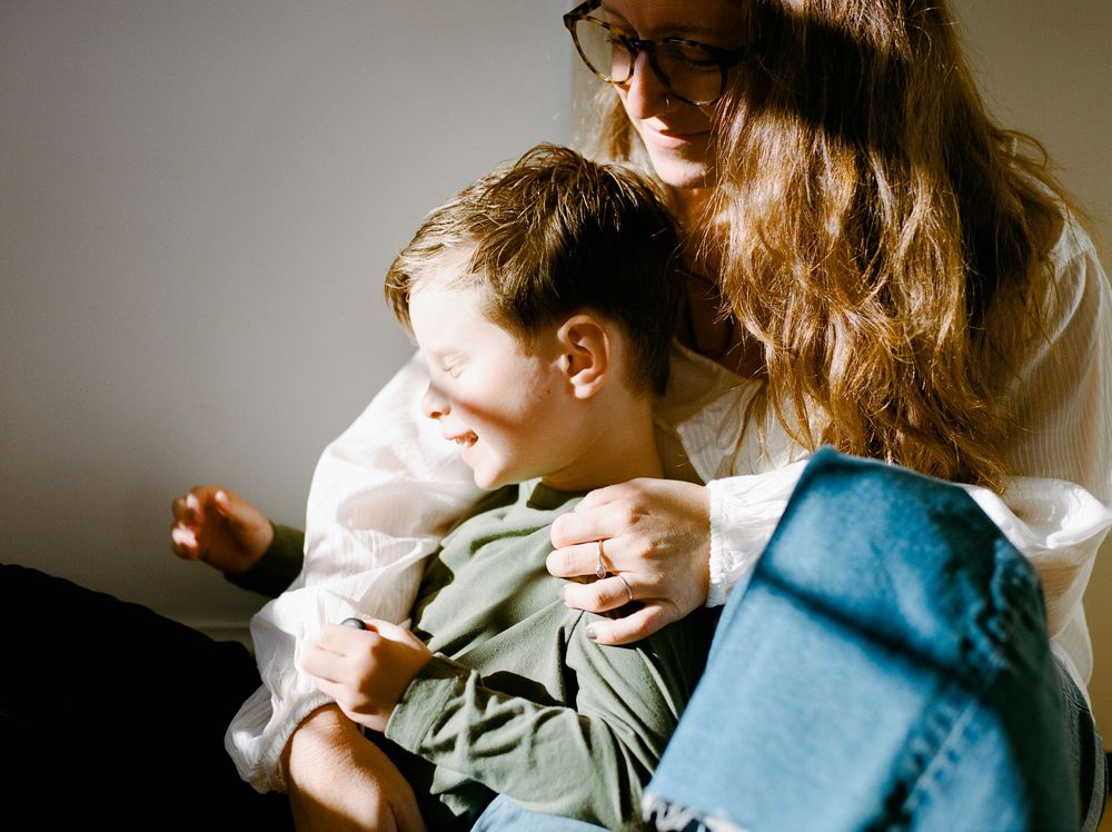 Candid indoor scene showing tender interaction between two people in soft natural lighting.
