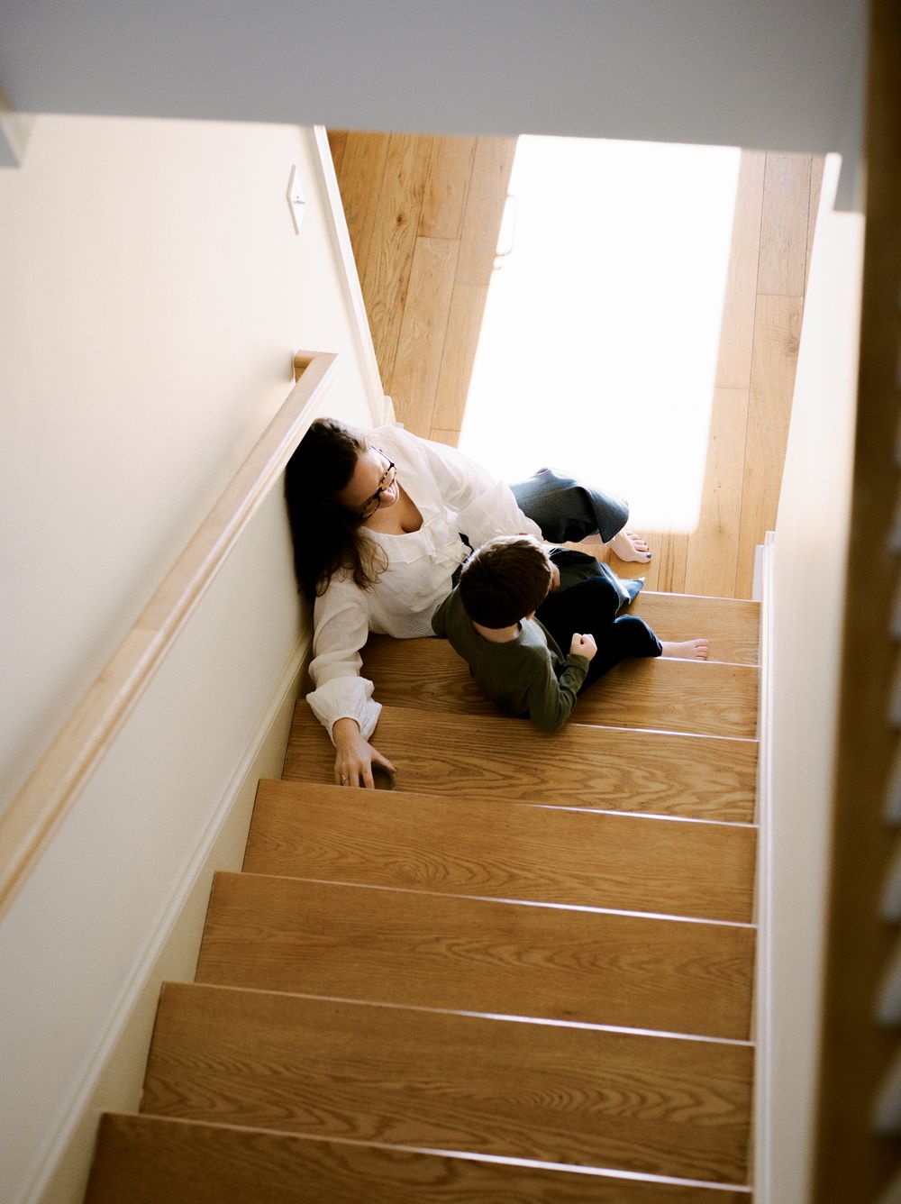 A person lying asleep on wooden stairs in a series of progressive shots showing different positions.