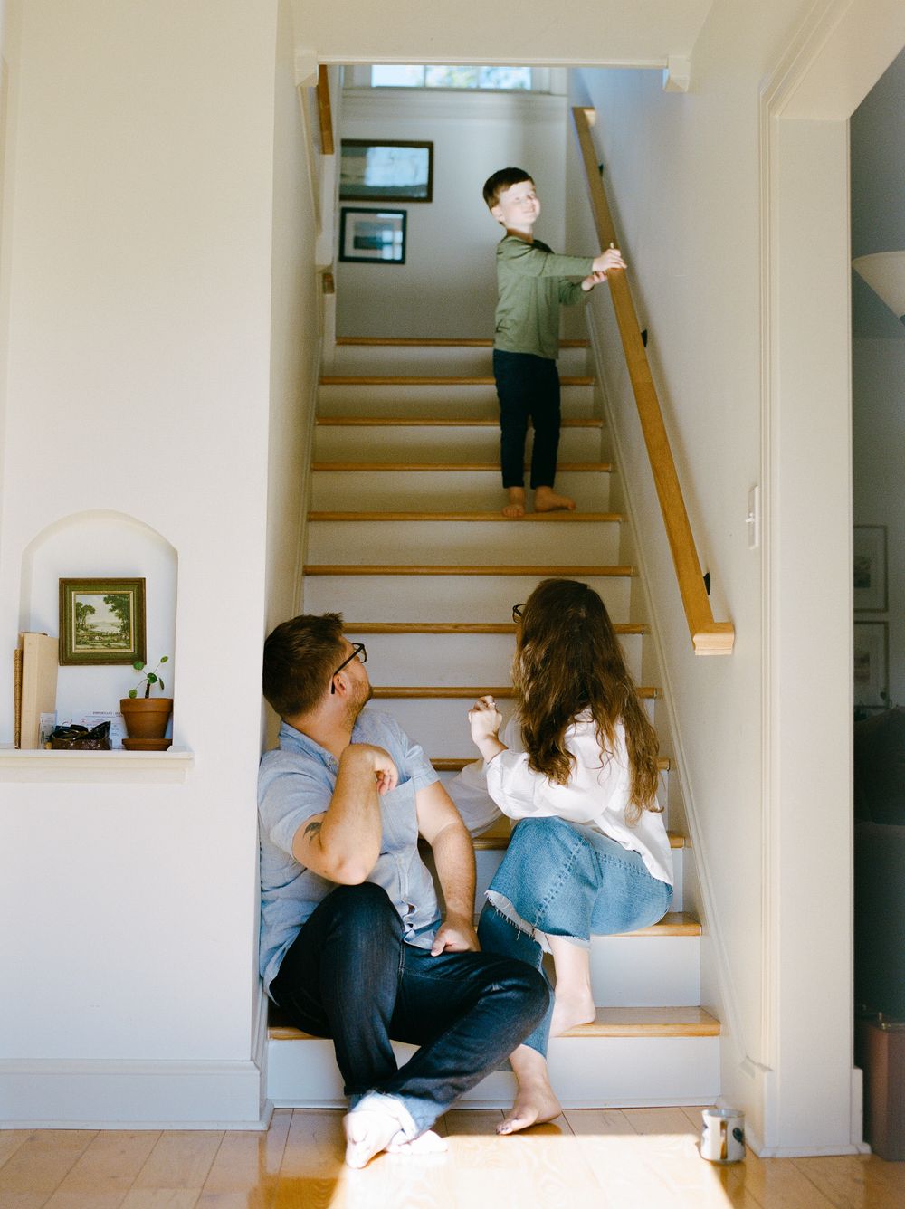 Casual indoor scene showing people interacting on white painted stairs.